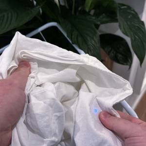 Ein getrockneter Kopfkissenbezug wird durch zwei Hände hochgehalten.