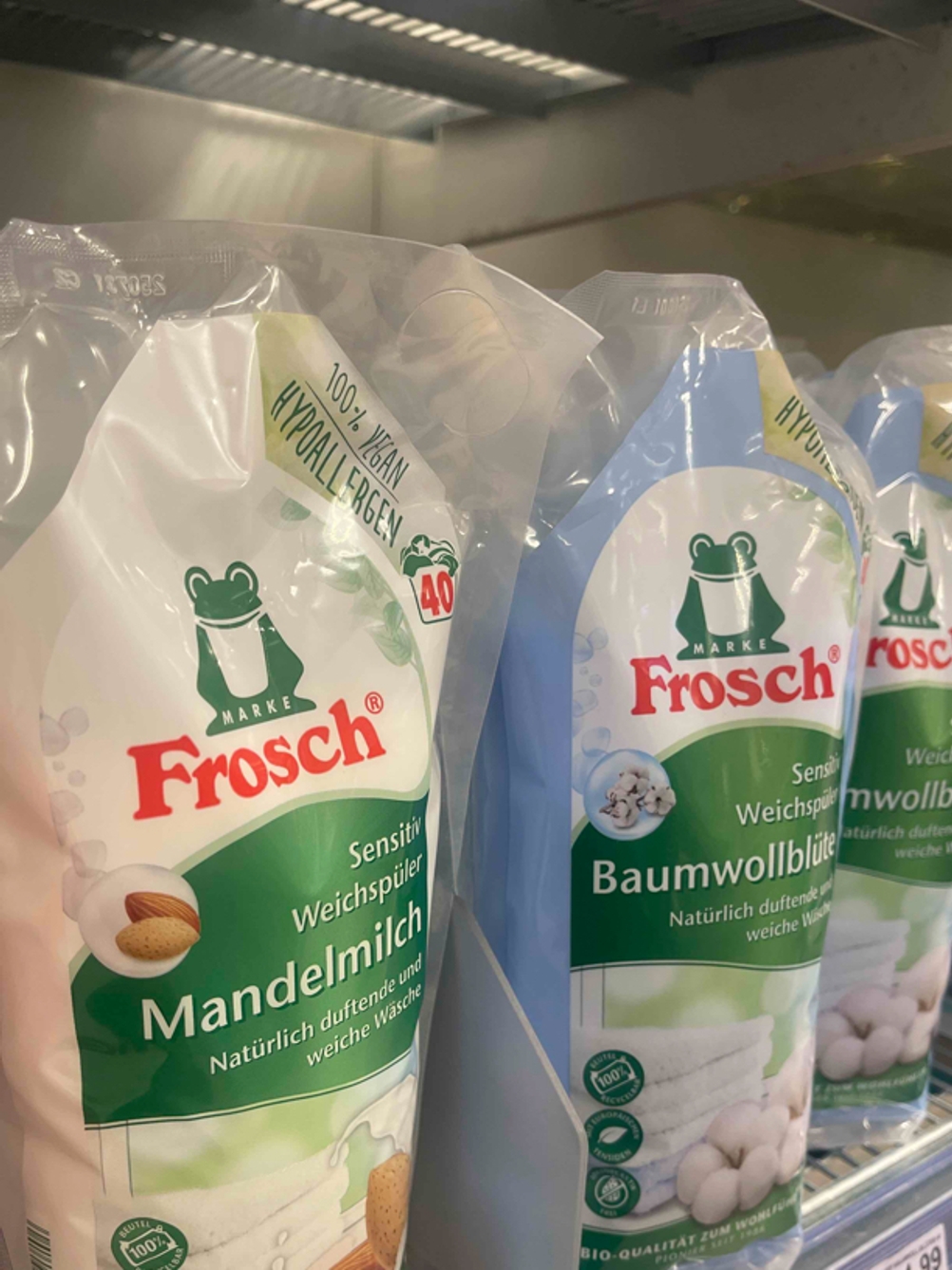 Mehrere Nachfüllbeutel mit unterschiedlichen Duftnoten des veganen Weichspülers im Test stehen in einem Verkaufsregal nebeneinander.