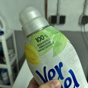 Eine Nahaufnahme der Flasche des veganen Weichspülers zeigt die 100-prozentige Abbaubarkeit.