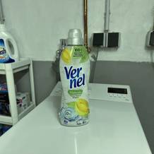 Eine Flasche veganer Weichspüler von Vernel steht auf einer Waschmaschine.
