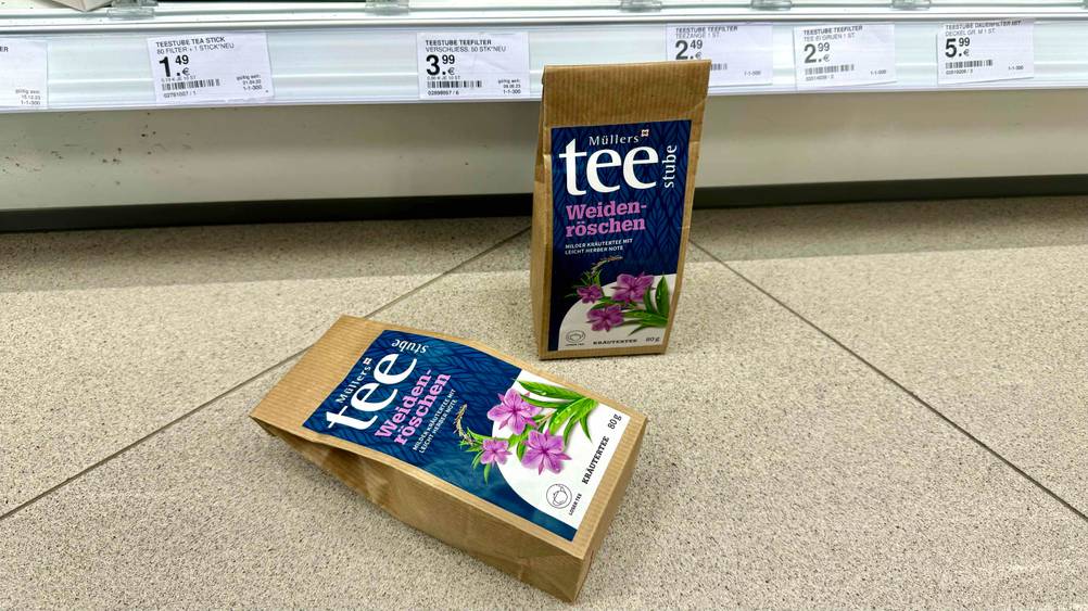 Getestet: Zwei Packungen Weidenröschen-Tee vor einem Verkaufsregal mit Preisen, eine stehend, eine liegend.