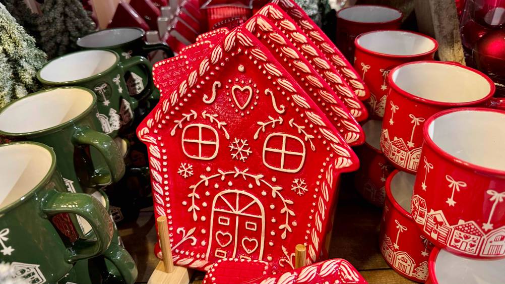 Zwischen Weihnachstassen stehen mehrere Teller des getesteten Weihnachtsgeschirrs.