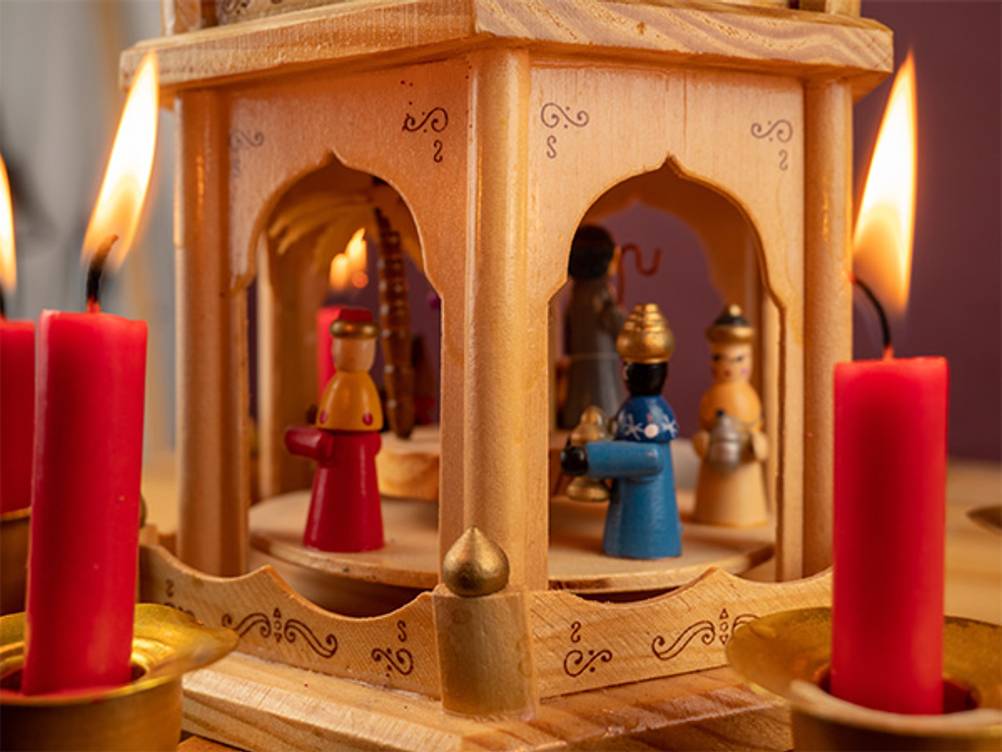 Weihnachtspyramide im Test: Detailansicht einer Weihnachtspyramide mit Figuren und echten Kerzen.