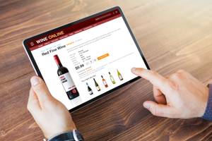 Test von Anbietern zum Wein kaufen: Eine Person bestellt über ein Tablet in einem Online-Shop Wein.