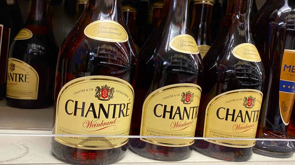 Mehrere Flaschen getesteter Weinbrand befinden sich im Supermarktregal. 