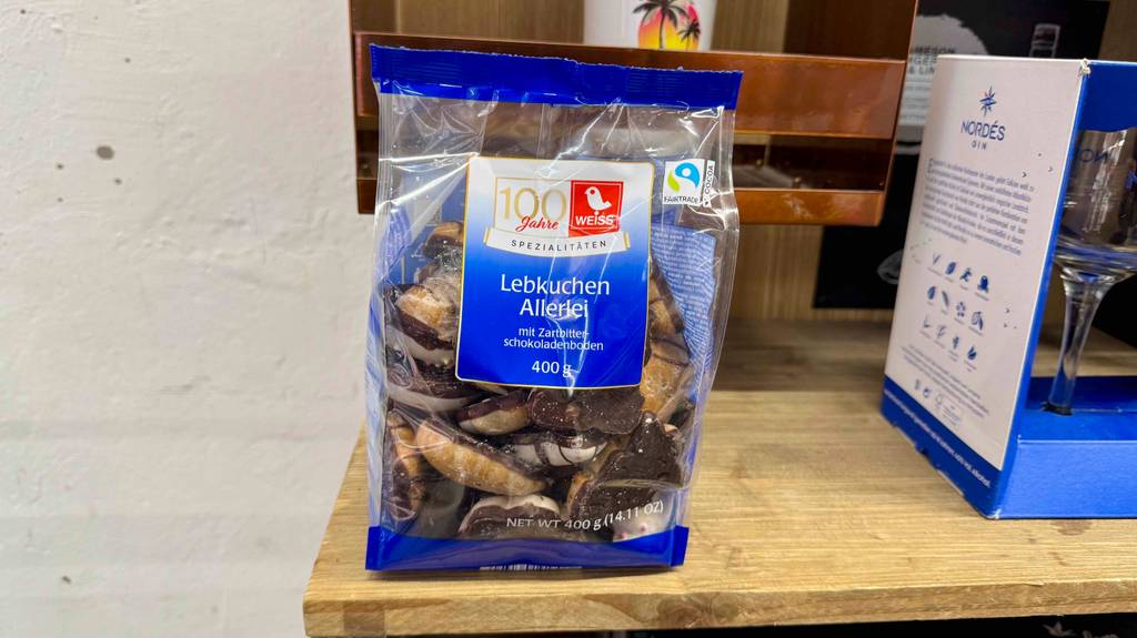 Eine Packung Weiss-Lebkuchen steht zum testen auf einem Holzregal.