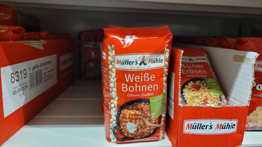 Eine Packung der weißen Bohnen im Test in einem Regal neben anderen Produkten.