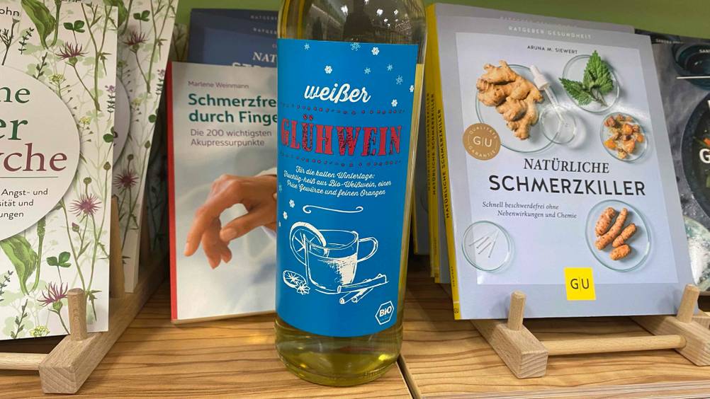Glühwein getestet: Nahaufnahme des Label einer Flasche die in einem Regal neben Büchern steht.