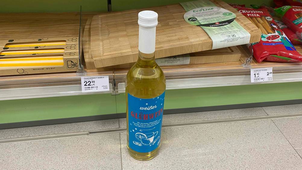 Eine Flasche getesteter Glühwein vor einem Regal mit anderen Produkten.