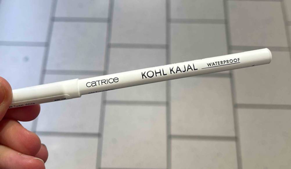 Der getestete weiße Kajal von einer Hand gehalten.