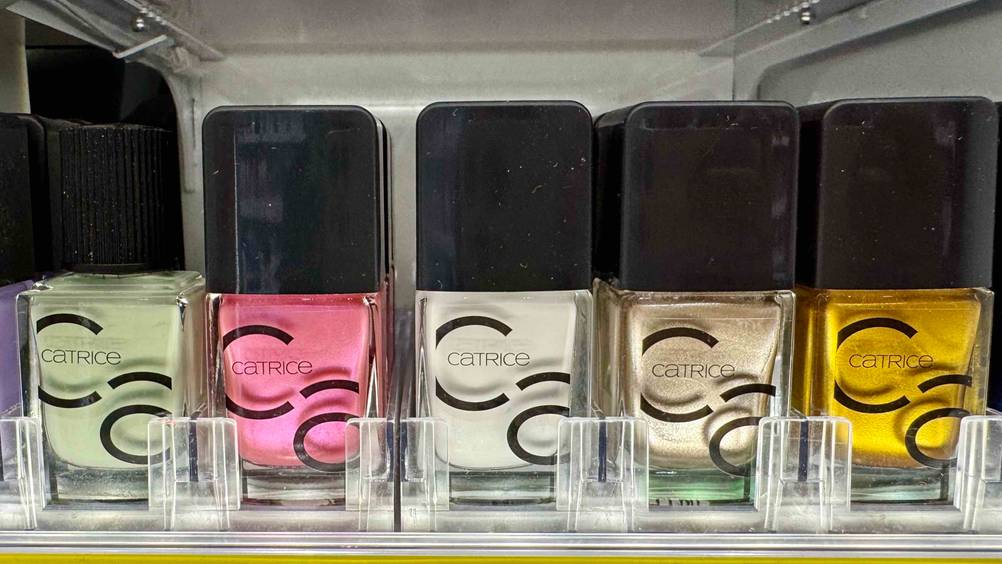 In einem Regal steht eine Flasche weißen Nagellacks im Test neben anderen Farben.