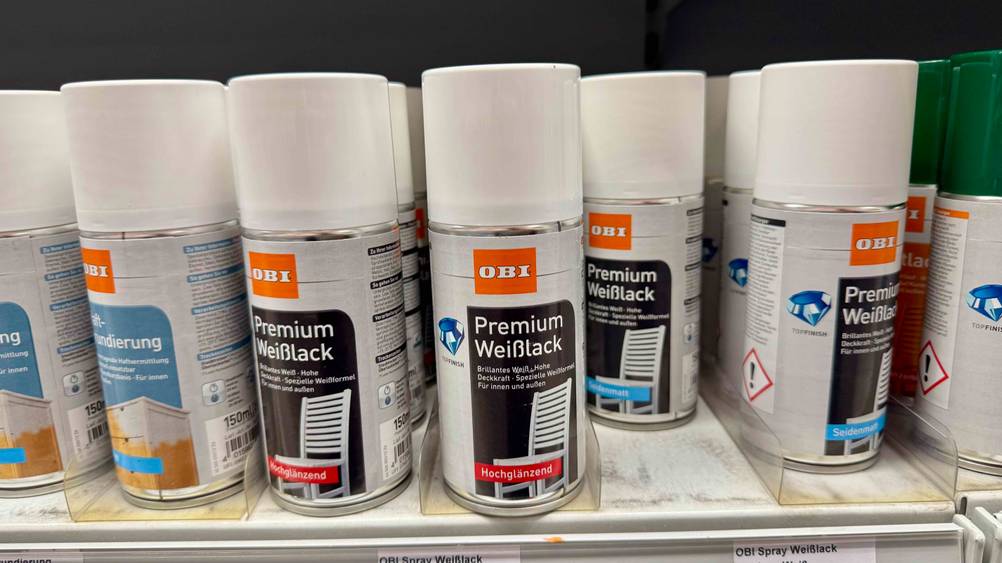 Mehrere Weißlacke in einem Verkaufsregal neben anderen Prokukten.