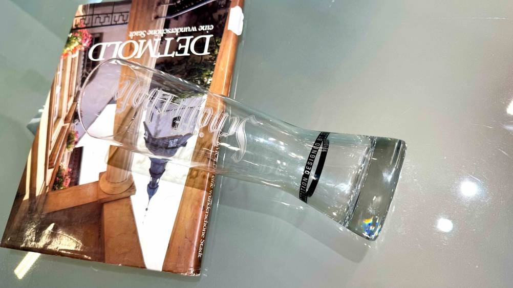 Getestet: Ein Weizenglas liegt auf einer Milchglasfläche auf einem Buch.