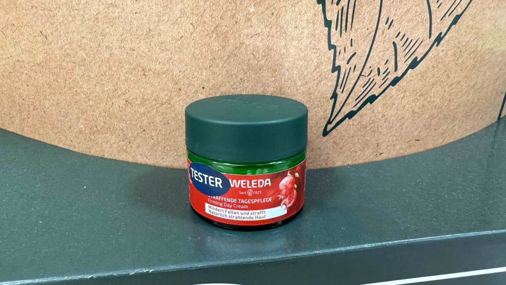 Eine Dose der getesteten Weleda-Gesichtscreme auf einer grünen Fläche.