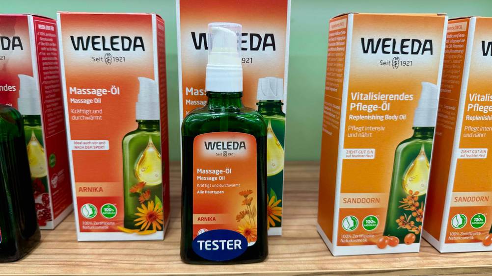 Ein getestetes Weleda-Massageöl steht vor seiner Originalverpackung.