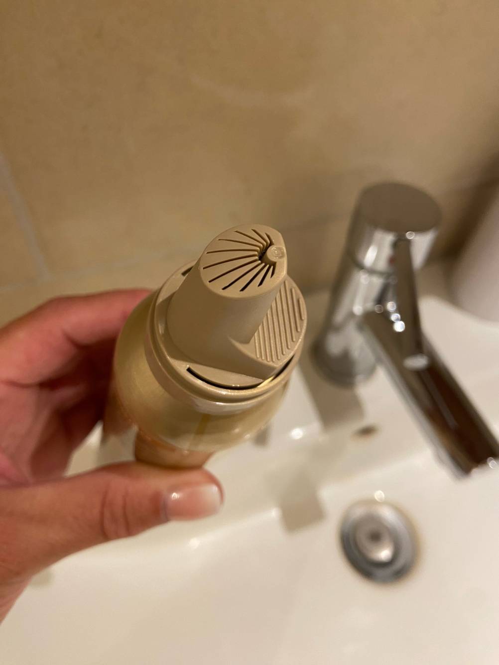 Wella-Schaumfestiger im Test: Eine Hand hält eine offene Flasche mit Blick auf den Sprühknopf.