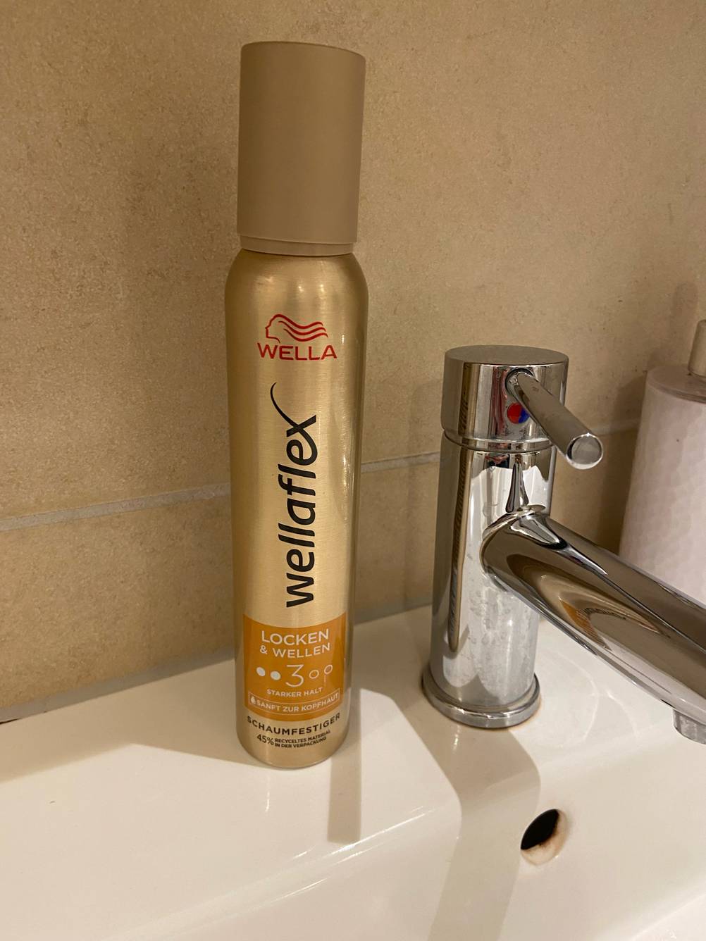 Eine Flasche Wella-Schaumfestiger steht zum testen auf einem Waschbecken.