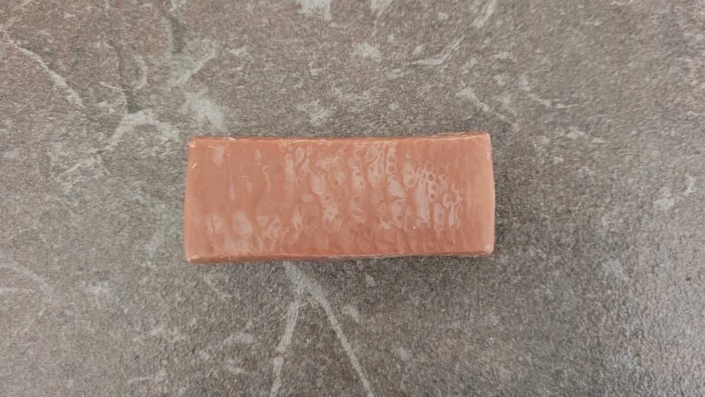 Getestet: Ein ausgepackter Proteinriegel von oben auf einer grauen Fläche.