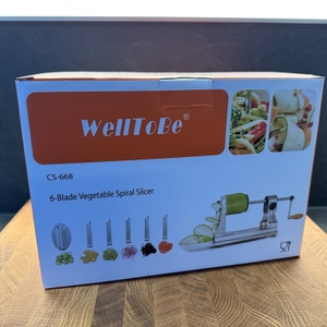 Auf einem Brett steht die Originalverpackung des WellToBe CS 668 Spiralschneiders.