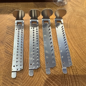 Vier Klingenaufsätze liegen nebeneinander auf einem Tisch.