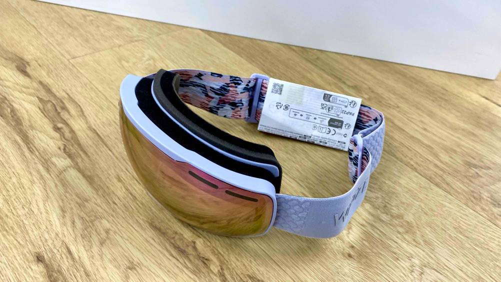 Eine getestete Crossbrille von schräg oben auf einem Holzboden.
