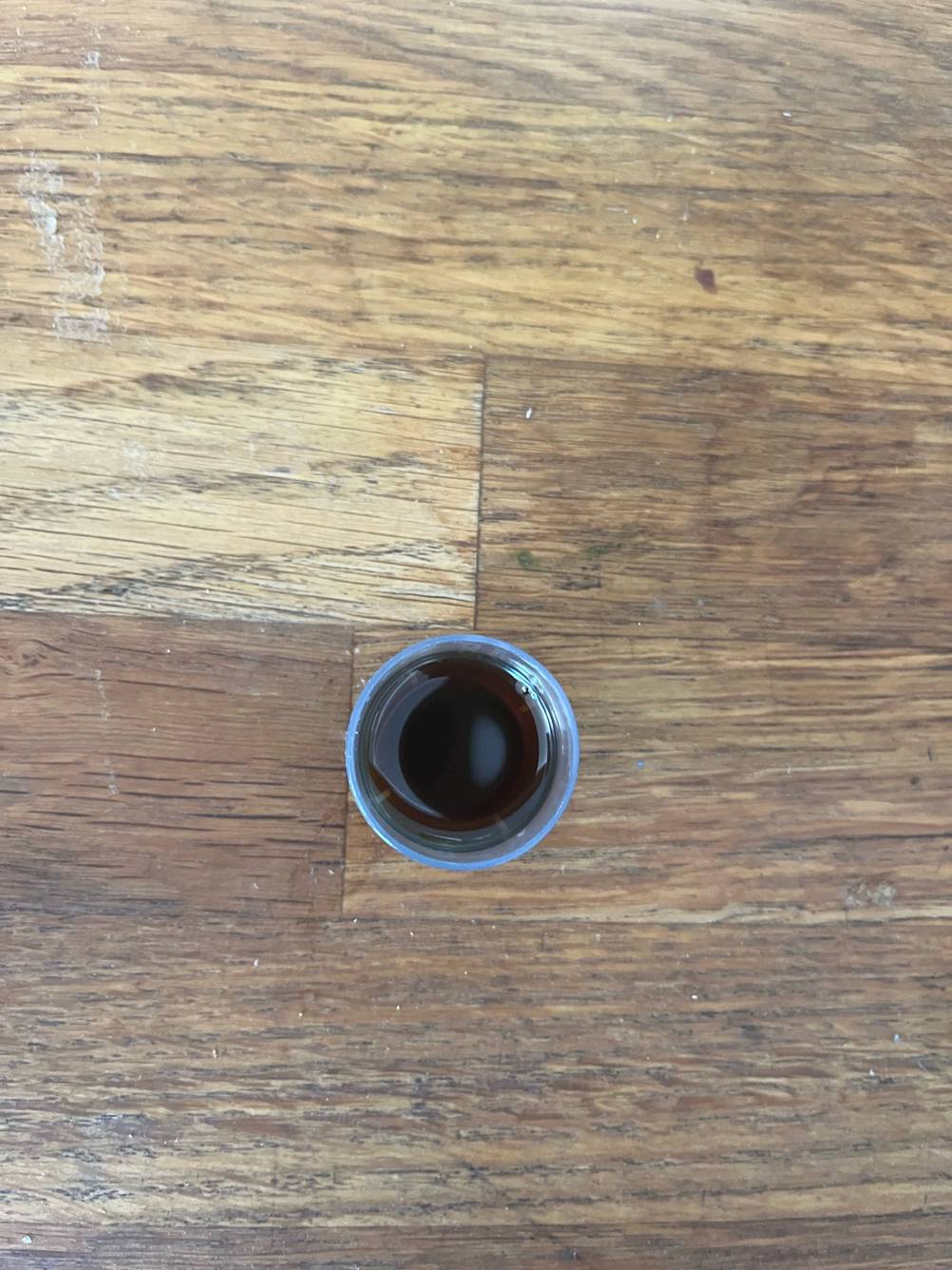 Im Test: Blick von oben auf einen mit Neemöl gefüllten kleinen Plastikdosierbecher.