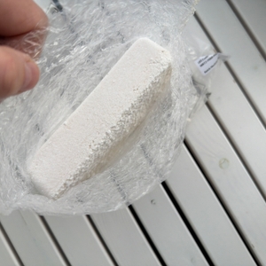 Ein Block Granulat aus dem Wenko-Nachfüllpack für Luftentfeuchter in seiner aufgeschnittenen Verpackung von oben