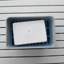 Ein Block Granulat aus dem Wenko-Nachfüllpack für Luftentfeuchter von oben in einem Luftentfeuchter