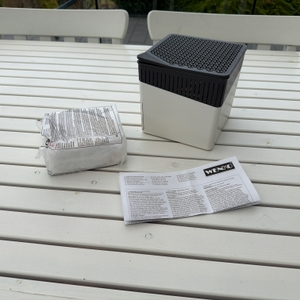 Der Lieferumfang des Wenko-Raumentfeuchters Cube WK50220 steht auf einem Tisch