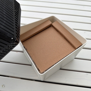 Ein Stück Pappe im Behälter vom Wenko-Raumentfeuchter Cube WK50220