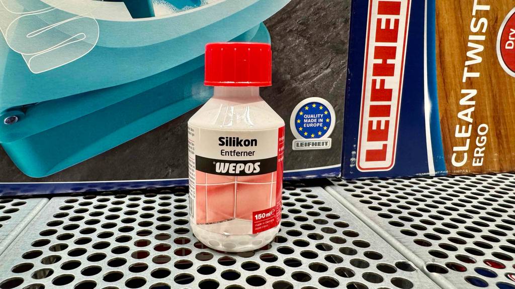 Eine Flasche Silikonentferner steht zum Testen vor einem Produktkarton.