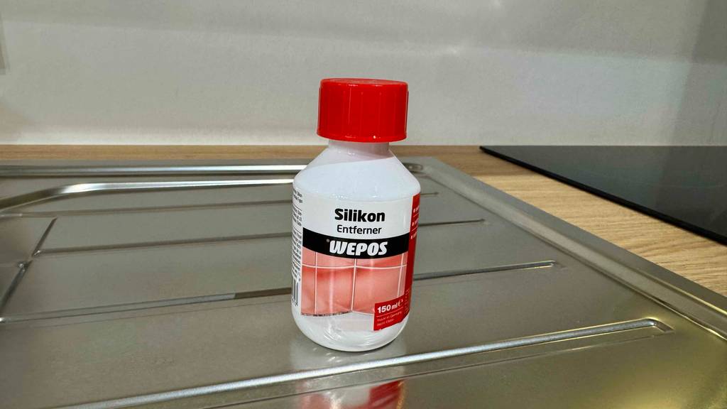 Eine Flasche getesteter Silikonentferner steht auf einer Abtropffläche.