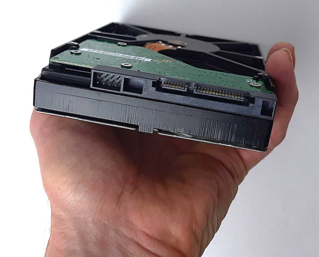 Eine Hand hält eine getestete 1TB-HDD mit Blick auf die Anschlüsse.