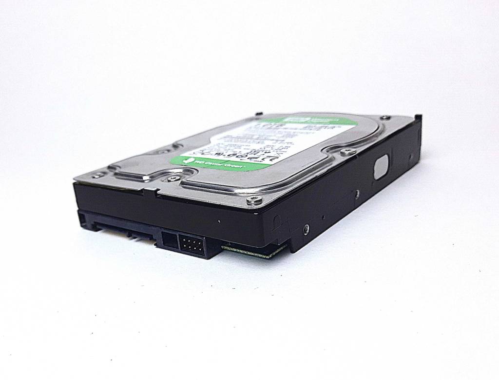 Blick von schräg vorn auf eine getestete 1TB-HDD, die auf einer weißen Fläche liegt.