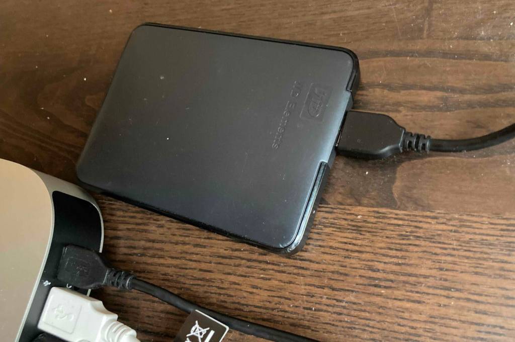 HDD-Festplatten-Test: ein Modell der Marke Western Elements liegt auf einer Holzoberfläche und ist an eine Computereinheit angeschlossen.