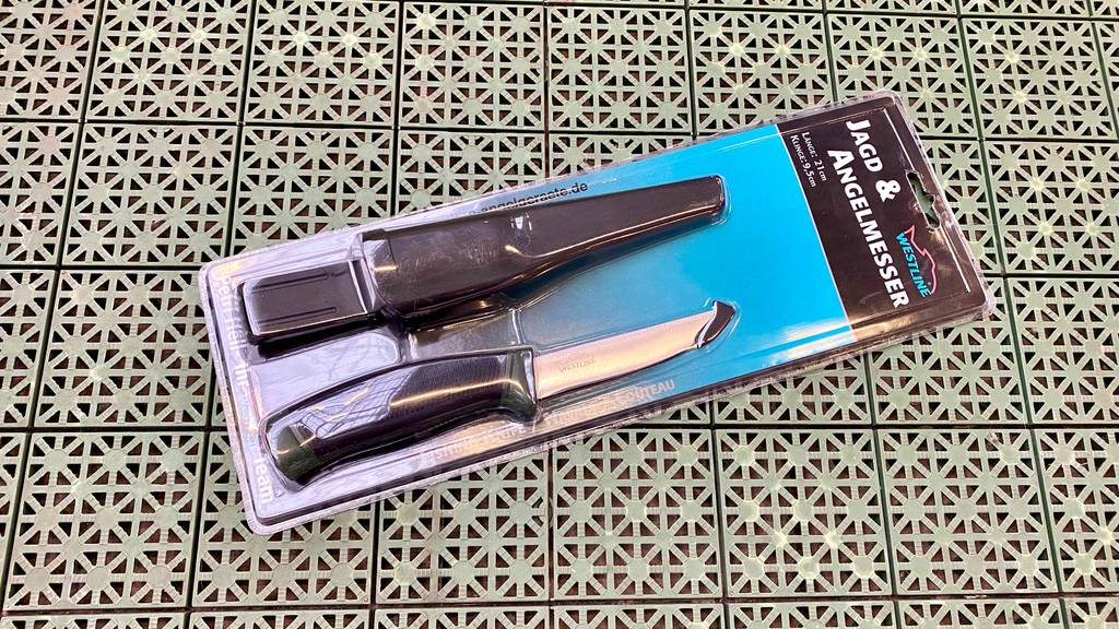Angelmesser getestet: Angelmesser in Verpackung liegt auf gemusterten Untergrund.