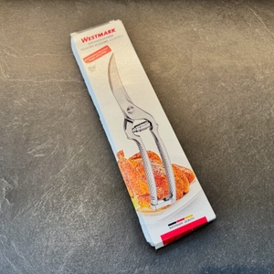 Die Verpackung der Westmark-Geflügelschere liegt auf einer Küchenarbeitsplatte