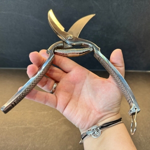 Eine Hand hält die vollständig geöffnete Westmark-Geflügelschere fest