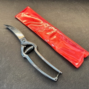 Die Westmark-Geflügelschere liegt neben ihrer Schutzhülle auf einer Arbeitsplatte.