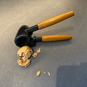 Eine geknackte Walnuss liegt neben dem Westmark-Nussknacker Sieger Nussprofi Deluxe