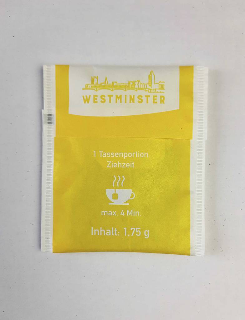 Ein getesteter grüner Tee im Beutel in Gelb liegt auf einer weißen Oberfläche.