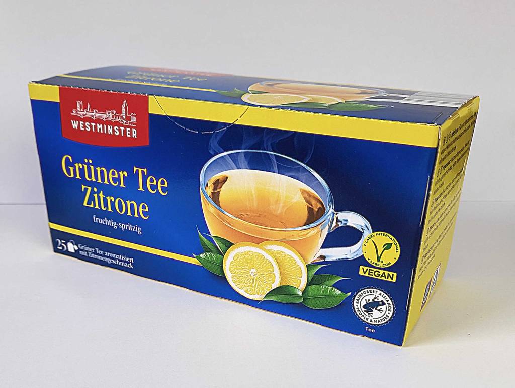 Getestet: grüner Tee im Beutel in seiner Verpackung, die auf einer weißen Oberfläche steht.