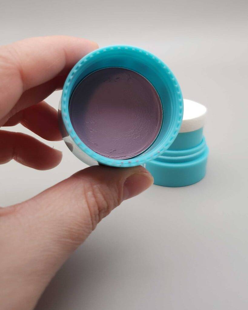 Getestet: Creme Rouge in einer von drei Fingern gehaltenen Dose.
