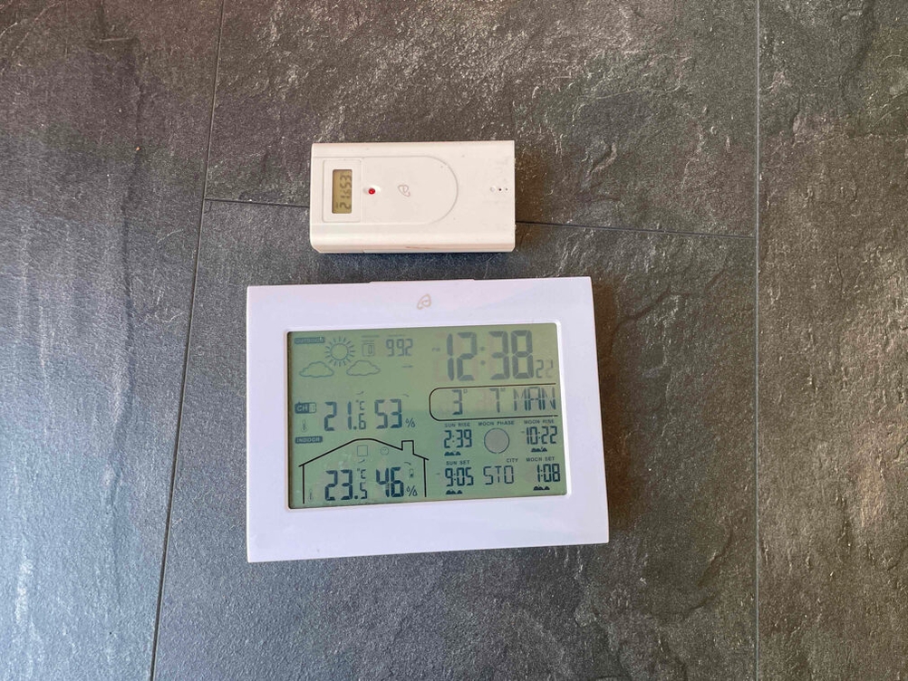 Wetterstation getestet: Das Anzeigedisplay und die Fernbedienung auf einem dunklen Boden liegend.
