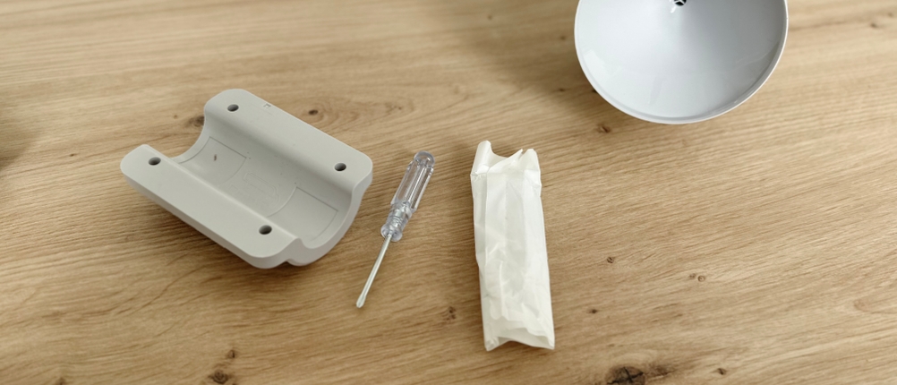 Befestigungsmaterial der Bresser-Wetterstation liegt auf einem Couchtisch.