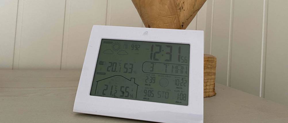 Eine eingeschaltete Wetterstation im Test steht auf einem Tisch.