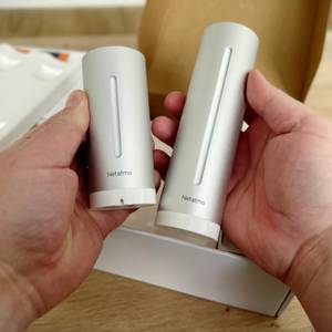 Außensensor und Basissation der Wetterstation von Netatmo werden nebeneinandergehalten.