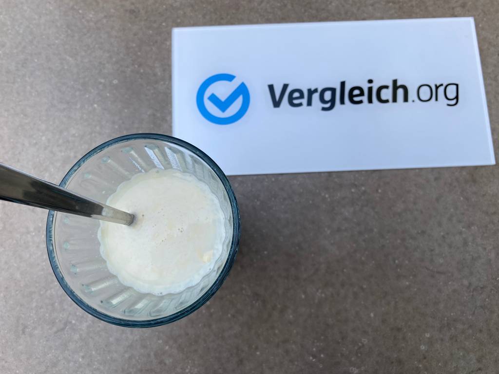 Whey-Protein in Wasser aufgelöst in einem Glas mit Löffel