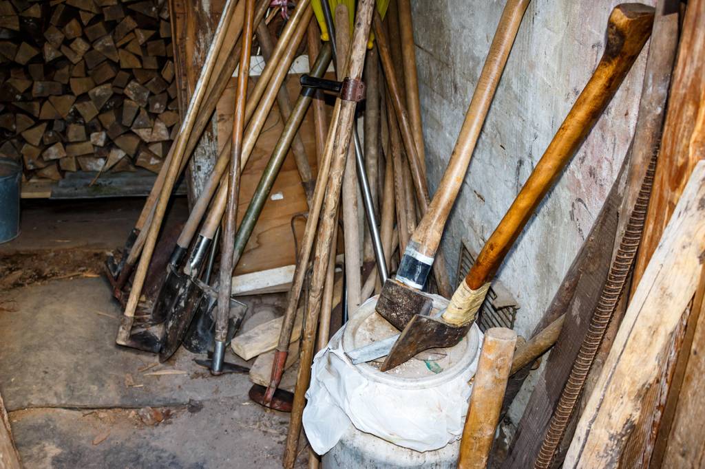 Wiedehopfhacke im Test: in einem Schuppen stehen viele Gartengeräte etwas chaotisch durcheinander an die Wand gelehnt.
