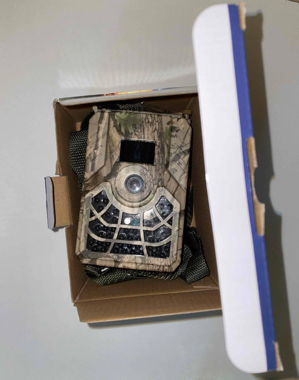 In einem geöffneten Karton liegt eine getestete Wildkamera mit Zubehör.